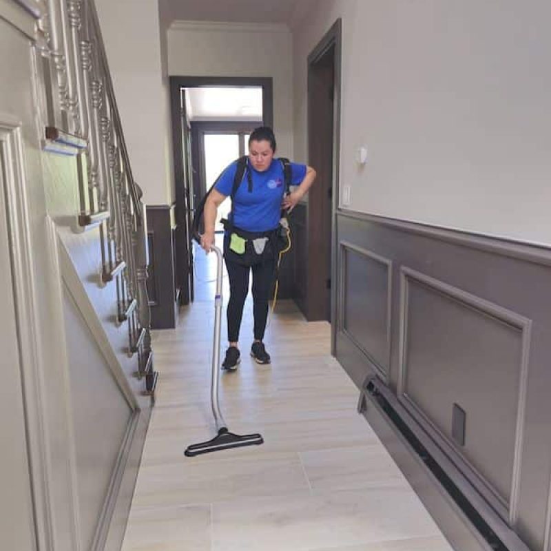 Roochii Cleaning professional vacuuming a hallway, ensuring a clean and spotless space with attention to detail.